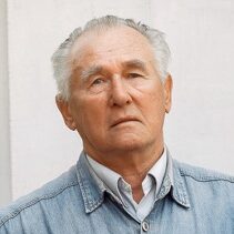 Grandfather in blue shirt. Old man with a book. Senior ongray background.